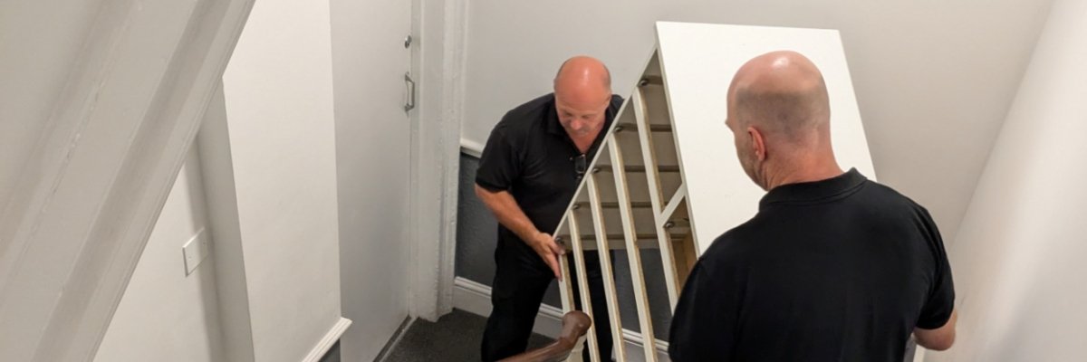 Swansea removals team moving furniture carefully through a property