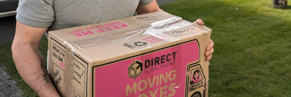Removal team member carrying a packed moving box